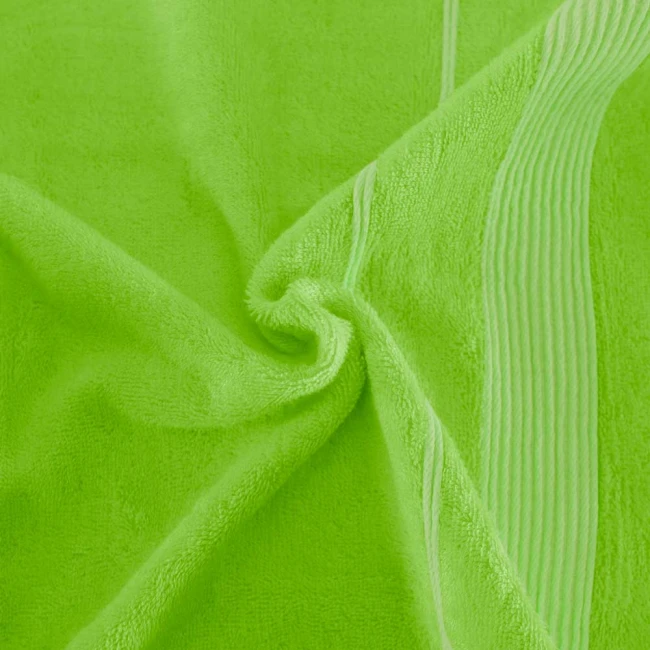 Ręcznik bambusowy 70x140 w kolorze limonki, miękki i teksturowany, z białymi paskami po bokach. Ułożony w sposób owijający, pokazujący fakturę materiału. Idealny do użytku w łazience lub na plaży.
