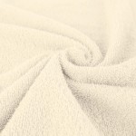 Ręcznik bawełniany 50x90 cm Solano w kolorze ecru, z teksturą pętelkową. Ułożony w lekkim zrolowaniu, widoczny detal materiału. Aktorzy neutralne tło, co podkreśla jego jasny kolor i miękkość.