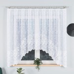 Firana żakardowa w kolorze białym, rozmiar 300x160 cm, zawieszona na karniszu, z falbaną na dolnej krawędzi. Delikatny wzór w formie spirali, lekko transparentna. Widoczna w aranżacji przy oknie, otoczone roślinnością.