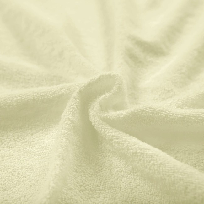 Pościel frotte 200x220 w kolorze kremowym, zbliżenie na miękką, teksturowaną powierzchnię materiału, ułożoną w naturalnych falach, podkreślającą jego grubość i jakość. Tło jednolite, co uwydatnia produkt.
