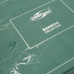 Zielone opakowanie pościeli bambusowej, na froncie widoczny napis DARYmex 1992 oraz BAMBOO COLLECTION. Na tle delikatny wzór bambusowych liści, całość matowa. Opakowanie o kwadratowym kształcie, widok z góry.
