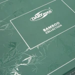 Zielone opakowanie z delikatnym, teksturowanym wzorem liści bambusa. Na przedniej stronie widnieje białe logo DARYmex oraz napis BAMBOO COLLECTION w wyraźnym, czytelnym kroju pisma. Opakowanie płaskie i zamknięte.
