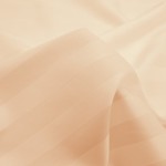 Poszewka bambusowa satyna bawełniana 50x60 w beżowym kolorze z delikatnym prążkiem. Ułożona w złożony sposób, ukazująca teksturę materiału. Idealna do dekoracji poduszek, wykonana z miękkiego i przyjemnego w dotyku włókna.