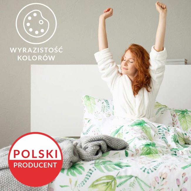 Pościel bawełniana 220x200 w kolorze szarym i białym z wzorem kratki, wykonana z dzianiny jersey. Złożona na łóżku z poduszkami, z widoczną narzutą w kolorze szarym. Kąt widzenia z przodu, na białym tle z elementami zielonymi w tle.