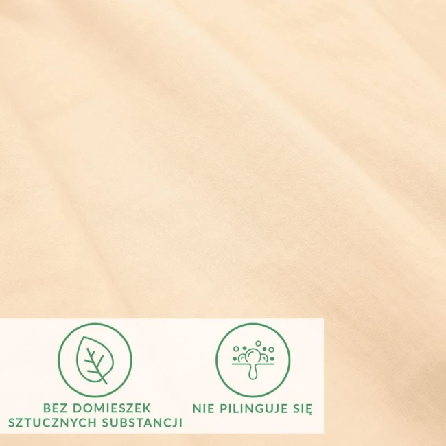 Prześcieradło jersey z elastanem w kolorze beżowym, gładkie i elastyczne, idealnie dopasowuje się do materaca 180x200 cm. Widoczne ikony informują o braku sztucznych substancji i o właściwościach antypilingowych materiału.