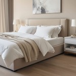 Prześcieradło jersey z elastanem z gumką 90x200 w kolorze białym na podwójnym łóżku, złożone pod stylowym kremowym kocem. W tle miękkie poduszki i minimalistyczna lampka. Ściana w odcieniu piaskowym dopełnia aranżację.