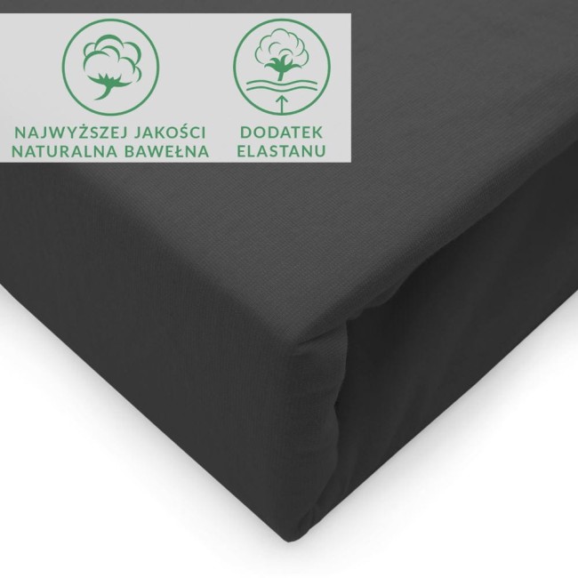 Czarny prześcieradło jersey z elastanem 200x220, leżące na gładkiej powierzchni. Widzimy szczegóły materiału oraz widoczne napisy o jakości bawełny i dodatku elastanu. Prześcieradło ma elastyczny brzeg.