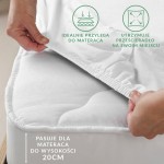 Prześcieradło flanelowe z gumką w kolorze jasno beżowym rozłożone na materacu, z widocznymi rozciągniętymi brzegami gumki. Ujęcie z góry, ręka przytrzymująca róg prześcieradła.