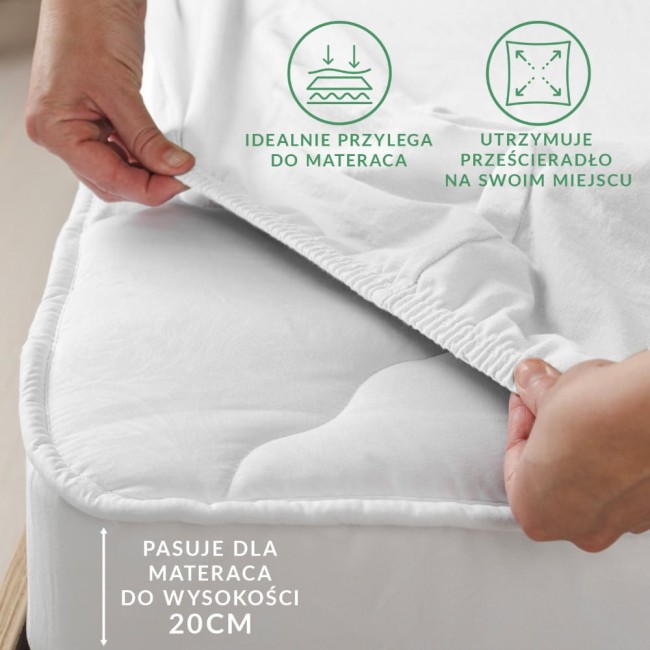 Prześcieradło flanelowe z gumką 90x200 w kolorze jasno beżowym, ułożone na materacu. Widać elastyczny brzeg, który idealnie przylega do wysokości materaca 20 cm. Grafiki na tle wskazują na funkcje utrzymywania prześcieradła na miejscu.