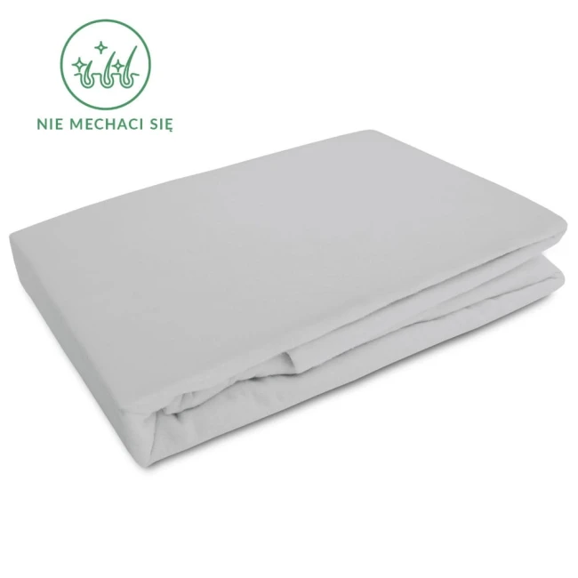 Flanelowe prześcieradło z gumką 160x200 w kolorze jasno szarym, o gramaturze 160 g/m², złożone na boku. Widoczna tekstura flaneli oraz nadruk z napisem nie mechaci się. Tło białe, co podkreśla wygląd produktu.