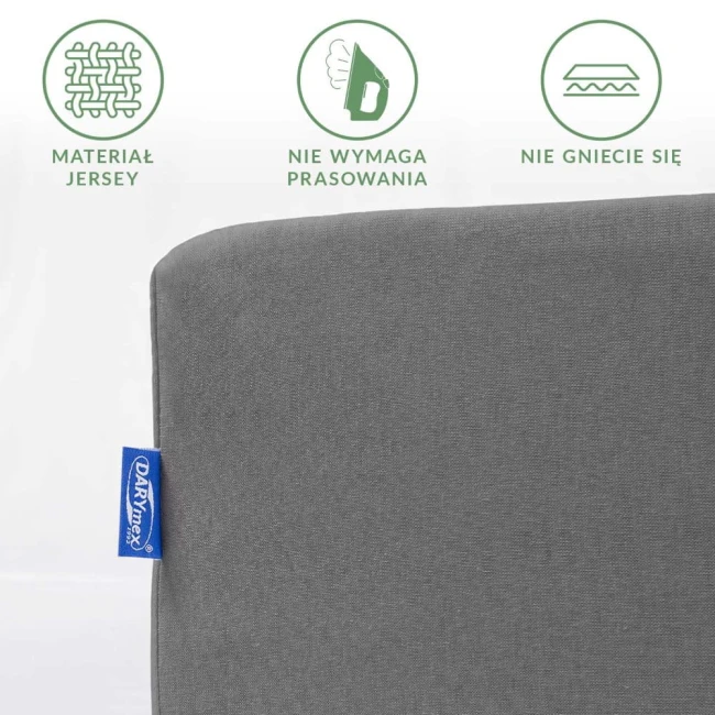 Prześcieradło jersey z gumką 120x200 w kolorze szarym, rozłożone na jednolitym tle. Zauważalne detale to logo producenta oraz informacje o materiale, braku potrzeby prasowania i odporności na gniecenie. Tekstura matowa, dobrze dopasowane krawędzie.