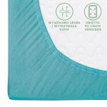 Prześcieradło jersey z gumką 120x200 w kolorze turkusowym, z widoczna grubą, elastyczną gumą obwodową. Ujęcie z boku ukazuje gładką fakturę materiału oraz oznaczenia na powierzchni. Prześcieradło rozłożone na boku materaca.