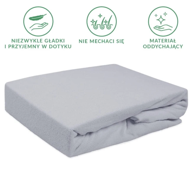 Prześcieradło frotte z gumką 90x200 w kolorze popielatym, leżące na białym tle. Materiał o teksturze przypominającej miękki polarek, idealnie dopasowujące się do materaca.