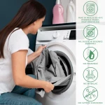 Prześcieradło frotte z gumką w kolorze popiel. Widoczne jest w dłoniach użytkownika, w trakcie wkładania do pralki. Tło stanowi ciemna ściana oraz sprzęt AGD. Przedmiot leży swobodnie, ukazując swoją gładką fakturę i elastyczny brzeg.