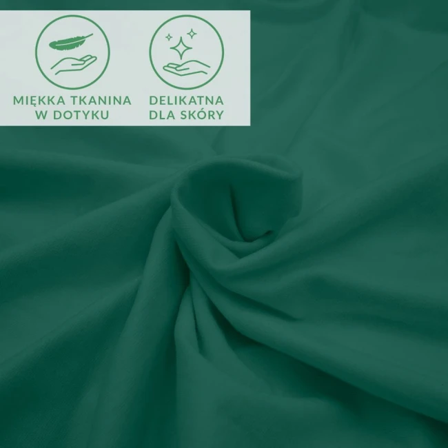 Prześcieradło jersey z elastanem w zielonym kolorze, wykonane z miękkiej tkaniny. Złożone na stole, eksponuje delikatną strukturę materiału. W lewym górnym rogu symbole: miękka tkanina w dotyku oraz delikatna dla skóry.