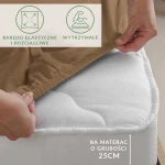 Prześcieradło jersey z elastanem w kolorze brązowym, rozłożone na białym materacu o grubości 25 cm. Ujęcie z boku, ukazujące elastyczny brzeg z gumką, łatwy do nałożenia. Na materiale widoczne logo i oznaczenia dotyczące elastyczności i trwałości.