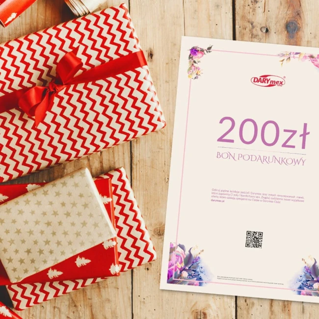 Karta podarunkowa o wartości 200 zł, umieszczona na drewnianym blacie, otoczona kolorowymi, ozdobnie zapakowanymi prezentami. Na białym tle znajdują się widoczne napisy „BON PODARUNKOWY” oraz logo DARYmex, ujęcie lekko z góry.