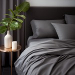 Poszewka satynowa 40x40 w kolorze szarym, leżąca na łóżku z widoczną fakturą, w towarzystwie poduszek. Ujęcie z góry z elementami dekoracyjnymi, takimi jak biały wazon i filiżanka na stoliku obok.