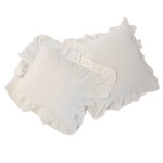 Pościel bawełniana z falbanką w kolorze ciepłej bieli, rozmiar 160x200. Znajdują się dwa poduszki o prostokątnym kształcie, z dekoracyjnymi falbankami na brzegach, leżące na płaskiej powierzchni, widoczne z góry.