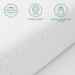Ochraniacz na materac w kolorze białym, pikowany, wykonany z materiału o wysokiej gramaturze 275 g/m². Zbliżenie na strukturę tkaniny z heksagonalnym wzorem. Widoczne symbole ekologiczne i jakościowe oznaczające produkt premium.