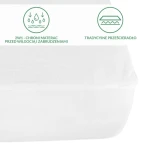 Ochronne prześcieradło z gumką 70x140 cm w kolorze białym, rozłożone na łóżku. Widoczne są ikony informacyjne dotyczące ochrony materaca przed wilgocią i zabrudzeniami oraz tradycyjnego prześcieradła. Tło białe, minimalistyczne.