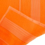 Ręcznik bambusowy 50x90 w kolorze pomarańczowym, z widocznym, gładkim wykończeniem oraz delikatnymi, poziomymi wzorami. Produkt leży na płaskiej powierzchni, ukazując teksturę materiału i estetyczne przeszycia.