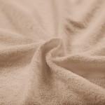 Pościel frotte w kolorze beżowym, rozłożona w delikatny sposób, ukazująca miękką, teksturowaną powierzchnię. Zdjęcie zbliżeniowe, skupiające się na fakturze materiału, bez widocznych napisów lub logo.