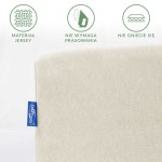 Prześcieradło jersey z gumką o wymiarach 120x200 w kolorze ecru. Złożone, widok z boku. Posiada metkę na jednej z krawędzi. Materiał nie wymaga prasowania i nie gnije się, co podkreślają widoczne ikony. Gładka tekstura.