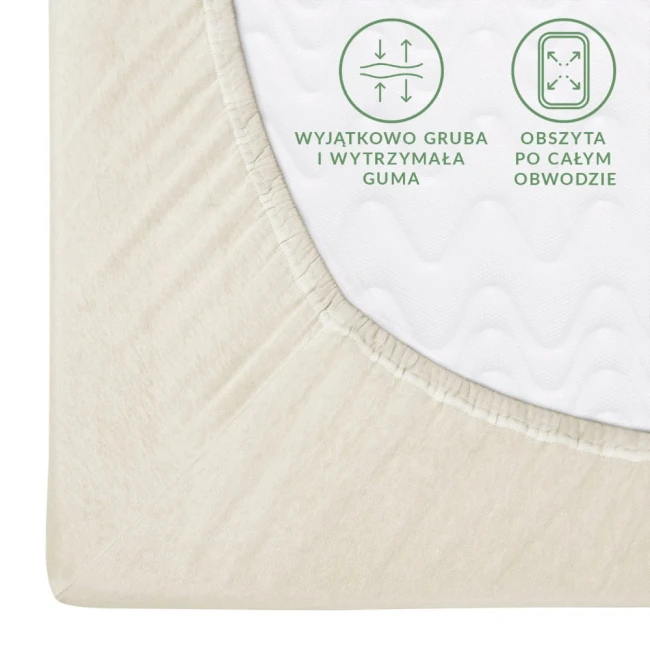 Prześcieradło jersey z gumką 200x220 w kolorze ecru, leżące w zbliżeniu. Widoczna gruba, elastyczna guma wszyta w obwód, zapewniająca mocne trzymanie. Na tkaninie widoczne delikatne wytłoczenia. Tło jednolite, jasne, podkreślające fakturę materiału.