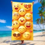 Ręcznik plażowy o wymiarach 100x180 cm wykonany z szybkoschnącej mikrofibry, w kolorze żółtym z motywem emotikonów. Produkt trzymany w pionie, ukazujący różne wyrażenia twarzy. Tło morskie, z palmami oraz plażą.