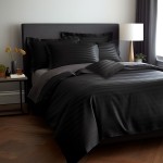 Pościel bambusowa satyna bawełniana 220x200 w kolorze czarnym z delikatnym paskiem. Ułożona na łóżku, sloughająca się na krawędzi. Zestaw zawiera poszewki na poduszki w różnych rozmiarach. Otoczenie z minimalistycznym nocnym stolikiem i lampą.