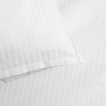 Pościel hotelowa bawełniana 220x200 w pasy 4-mm biała na zakładkę 30 cm, zbliżenie na poszewkę i część prześcieradła. Materiał o gładkiej fakturze, cienkie, białe pasy zapewniają elegancki wygląd. Widoczny detal zakładki i przeszycia.