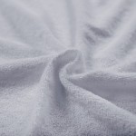 Pościel frotte w kolorze jasno szarym, popiel, składająca się z jednego prześcieradła 200x220 cm oraz dwóch poszewek 80x80 cm. Materiał teksturowany, delikatny w dotyku, ukazany w zbliżeniu, na lekko pofałdowanej powierzchni.