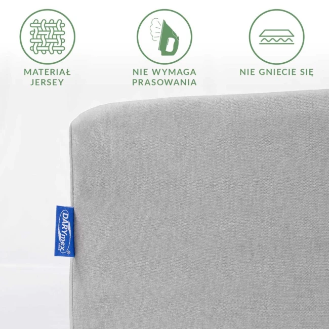 Prześcieradło jersey w kolorze popielatym o wymiarach 60x120 cm. Widoczny fragment z logo, ukazujący gładką fakturę materiału, który nie wymaga prasowania. Ujęcie frontalne, na jednolitym tle, bez dodatków.